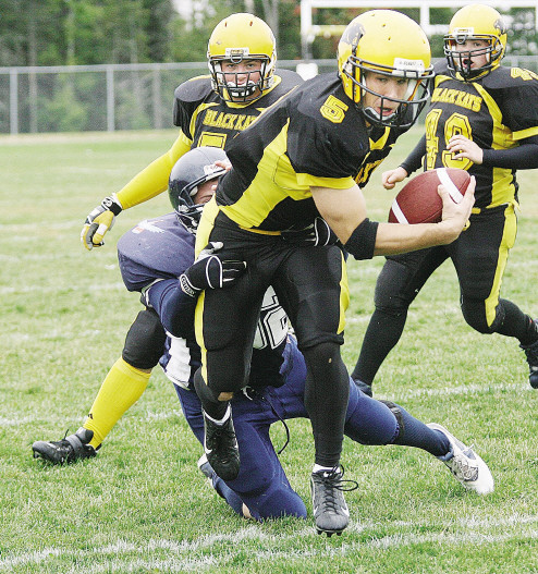 Fredericton High School Black Kats' quarterback Andrew Hickey tries to weave 